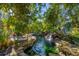 Beautiful backyard pond with a waterfall, plants, and stone borders at 4311 Bay Shore Rd, Sarasota, FL 34234