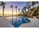 Sparkling pool surrounded by palm trees and lush greenery, offering a tranquil waterfront setting at 4311 Bay Shore Rd, Sarasota, FL 34234