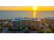 Aerial view of beachfront building at sunset, showcasing oceanfront location at 565 Sanctuary Dr # A203, Longboat Key, FL 34228