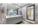 Elegant bathroom with double sinks, patterned wallpaper and a large mirror at 565 Sanctuary Dr # A203, Longboat Key, FL 34228