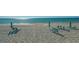Relaxing beach area with lounge chairs and umbrellas at 565 Sanctuary Dr # A203, Longboat Key, FL 34228