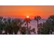 Stunning sunset over the ocean, palm trees silhouetted against vibrant sky at 565 Sanctuary Dr # A203, Longboat Key, FL 34228