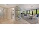 Open concept dining area with glass partition separating living room at 565 Sanctuary Dr # A203, Longboat Key, FL 34228