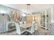 Modern dining room featuring a white table and coastal artwork at 565 Sanctuary Dr # A203, Longboat Key, FL 34228