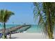 Beach pier view with palm trees and blue water at 639 Cornwell On The Gulf, Venice, FL 34285