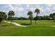 Expansive green golf course with palm trees and a golf cart at 7323 Oak Moss Dr # 42, Sarasota, FL 34241