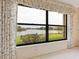 Bedroom with a picturesque lake view from large window at 7323 Oak Moss Dr # 42, Sarasota, FL 34241