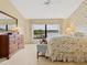 Spacious main bedroom with lake view, floral bedding, and dresser at 7323 Oak Moss Dr # 42, Sarasota, FL 34241