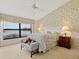 Main bedroom with lake view, floral bedding, and a dresser at 7323 Oak Moss Dr # 42, Sarasota, FL 34241