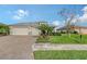 Tan two-car garage home with paver driveway and lush landscaping at 1015 Calico Gln, Bradenton, FL 34212