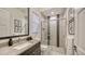 Modern bathroom with a walk-in shower and a vanity with a large mirror at 1206 Blue Shell Loop, Sarasota, FL 34240