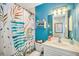 Charming bathroom with teal walls, white vanity, and a tropical shower curtain at 1323 Mediterranean Dr # 111, Punta Gorda, FL 33950