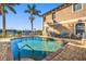 Community pool with patio furniture and palm trees at 1323 Mediterranean Dr # 111, Punta Gorda, FL 33950