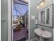 Powder room with pedestal sink, view of screened patio with lounge chairs at 15312 Spanish Point Dr, Port Charlotte, FL 33981