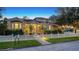 Evening view of charming two-story house with white picket fence and landscaping at 1714 Irving St, Sarasota, FL 34236