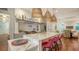 Island kitchen features marble countertops, pink stools, and built-in shelving at 1714 Irving St, Sarasota, FL 34236