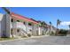 Exterior view of condo building with parking and tropical landscaping at 1801 Gulf N Dr # 256, Bradenton Beach, FL 34217