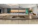 Modern kitchen with island and sunset view at 188 Golden Gate Pt # 202, Sarasota, FL 34236