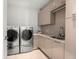 Bright laundry room with modern washer, dryer, and cabinets at 188 Golden Gate Pt # 202, Sarasota, FL 34236