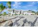 White two-story house with gray paver driveway, landscaping, and palm trees at 2287 Bayshore Rd, Nokomis, FL 34275