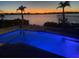 Inviting, illuminated pool at night overlooking the waterfront at 2287 Bayshore Rd, Nokomis, FL 34275