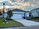 Modern house with white exterior, two-car garage, and nicely landscaped lawn at 2943 Greenleaf Ter, Parrish, FL 34219