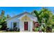 White house with red door, landscaping, and palm trees at 606 19Th W Ave, Palmetto, FL 34221