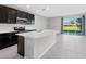 Modern kitchen with dark cabinetry, island, and tiled floors at 6108 Willowside St, Palmetto, FL 34221