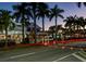 Night view of a palm tree-lined street with shops and light trails at 932 Capri Isles Blvd # 216, Venice, FL 34292