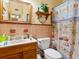 Functional bathroom featuring a classic sink, toilet, and vintage shower curtain at 1000 Dartmouth Dr, Bradenton, FL 34207