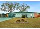 Ranch-style home with green exterior, mature trees, and landscaped yard at 1000 Dartmouth Dr, Bradenton, FL 34207