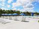Community pool area with tables, chairs, and umbrellas at 1000 Dartmouth Dr, Bradenton, FL 34207