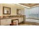 Elegant bathroom with double vanity, granite countertop, and a corner tub at 1965 White Feather Ln, Nokomis, FL 34275
