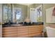 Modern bathroom with wood vanity, granite countertop, and large mirror at 1965 White Feather Ln, Nokomis, FL 34275