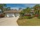 House exterior featuring a three-car garage and lush landscaping at 1965 White Feather Ln, Nokomis, FL 34275