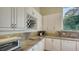 Modern kitchen with white cabinets, granite countertops, and wine rack at 1965 White Feather Ln, Nokomis, FL 34275