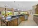 Kitchen with large island, granite countertops, and views to the pool at 2123 Calusa Lakes Blvd, Nokomis, FL 34275