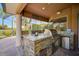 Outdoor kitchen with built-in grill, granite countertop, and stone facade at 2123 Calusa Lakes Blvd, Nokomis, FL 34275