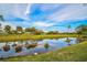 Serene view of pond reflecting palm trees and lush golf course at 2123 Calusa Lakes Blvd, Nokomis, FL 34275