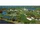 Aerial view of a golf course community with a clubhouse and waterfront property at 293 Turquoise Ln, Osprey, FL 34229