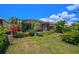 Landscaped backyard with a large screened patio and lush greenery at 293 Turquoise Ln, Osprey, FL 34229