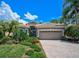 Attractive single-story home with a gray exterior, tile roof, and landscaped front yard at 293 Turquoise Ln, Osprey, FL 34229