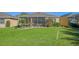 Landscaped backyard showcasing a home with a screened patio at 322 Siena Vista Pl, Sun City Center, FL 33573