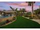 Landscaped backyard with artificial turf and tropical plants near the pool at 4817 Ocean Blvd, Sarasota, FL 34242