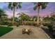 Tranquil backyard with fire pit, palm trees, and water views at 4817 Ocean Blvd, Sarasota, FL 34242