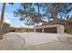 Three-car garage and house exterior on a sunny day at 4817 Ocean Blvd, Sarasota, FL 34242