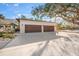 Two-car garage with dark brown doors and large driveway at 4817 Ocean Blvd, Sarasota, FL 34242