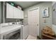 Laundry room with washer, dryer, and storage cabinets at 4817 Ocean Blvd, Sarasota, FL 34242
