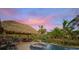 Tropical tiki hut pool area with lounge chairs and a tranquil water feature at 4817 Ocean Blvd, Sarasota, FL 34242