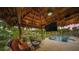 Relaxing poolside patio with thatched roof and comfortable seating at 4817 Ocean Blvd, Sarasota, FL 34242